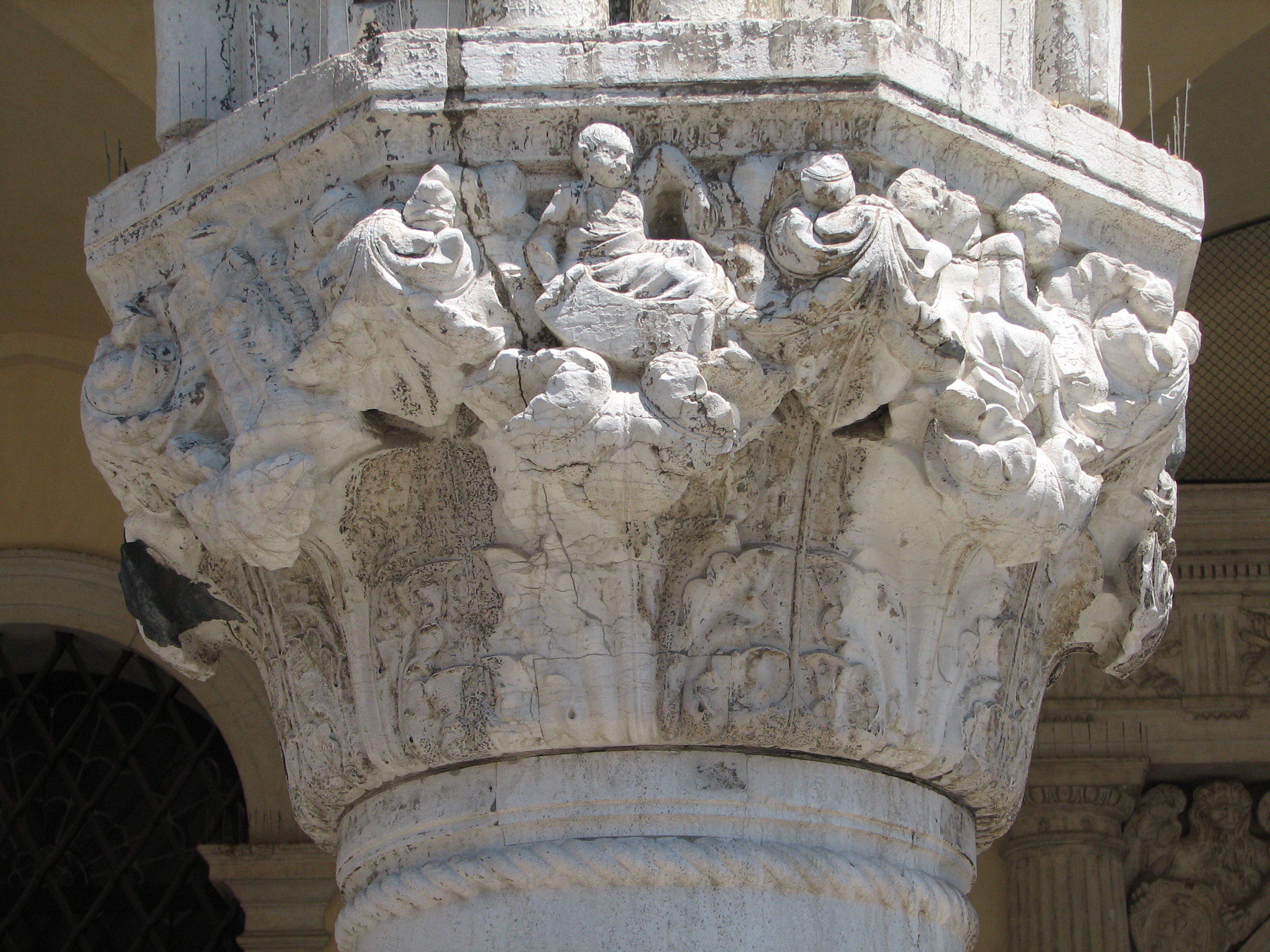 Detail of 22nd capital in its current state Death, side 8, left; Infancy, side 1, centre; Childhood, side 2, right