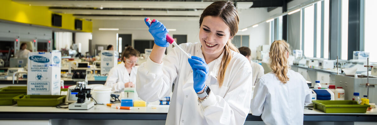 A student in a laboratory using a micropipette