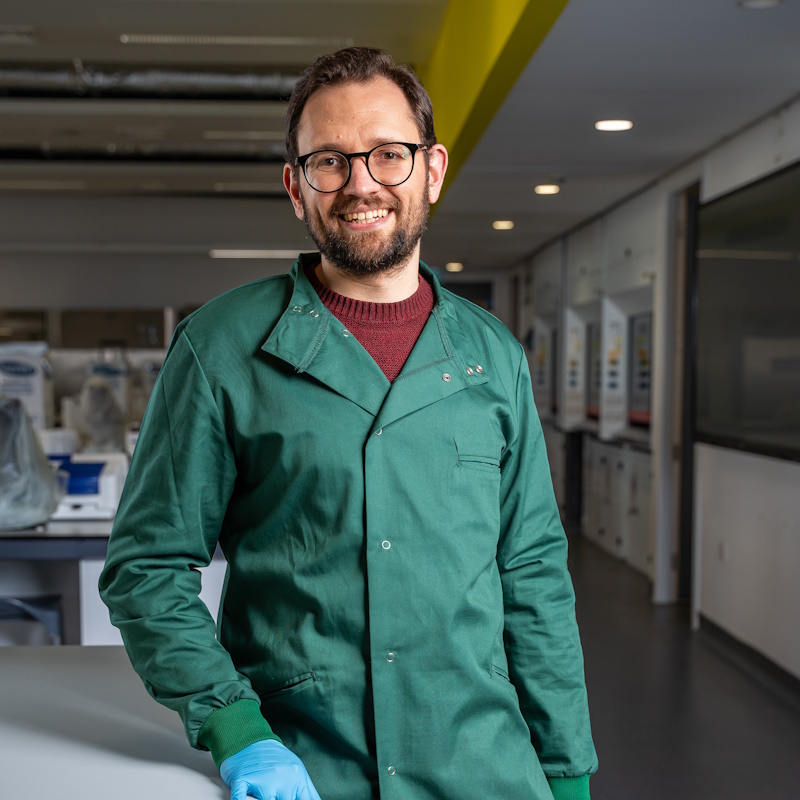 Dr Steve Hall, wearing a green lab coat in the teaching laboratory