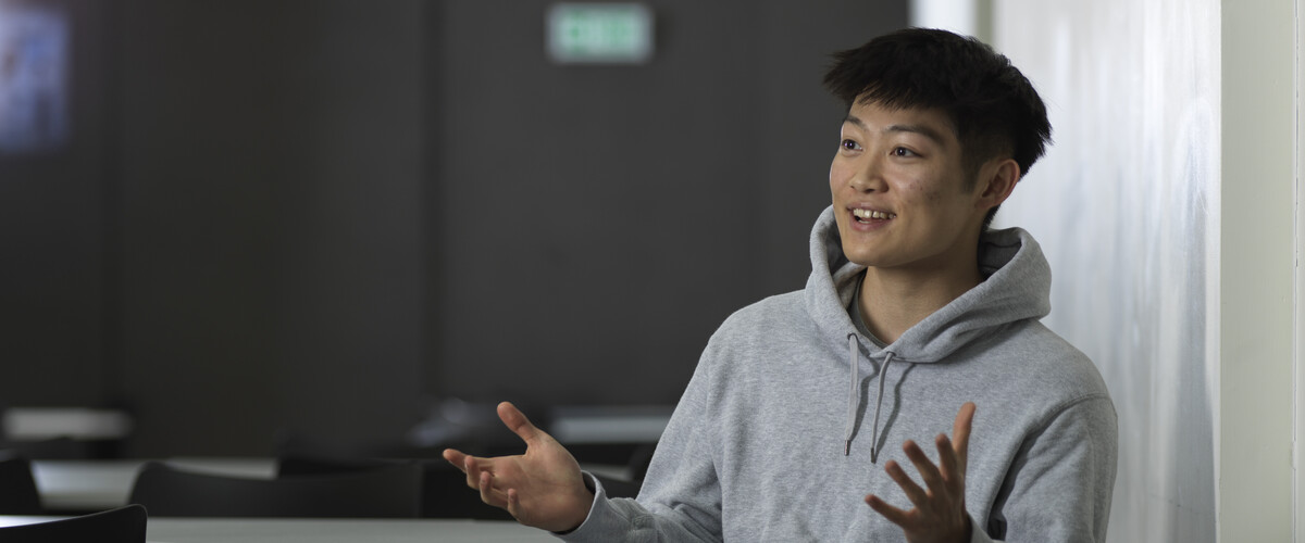 Image of student smiling and talking with hands