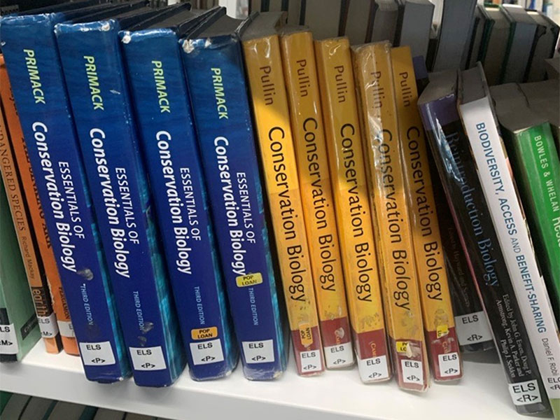 Biology textbooks on a shelf in the library.