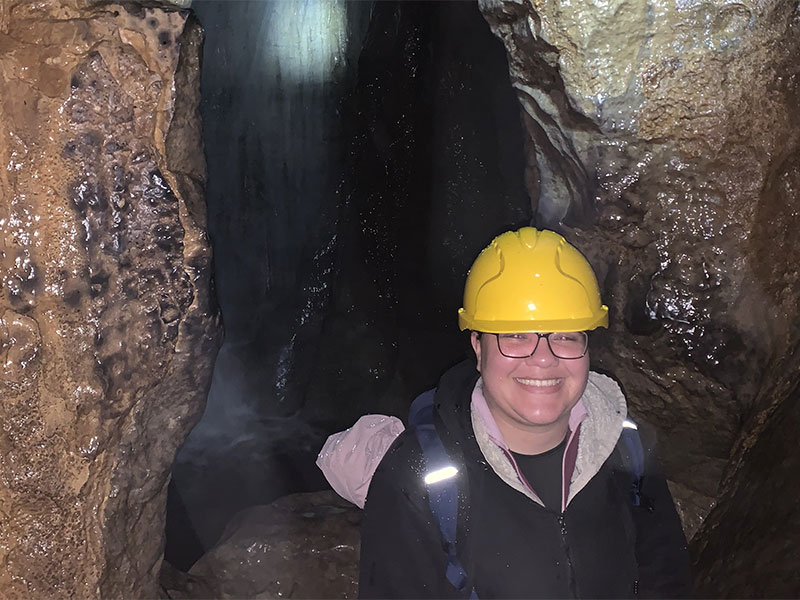 Student Lyea standing in a cave.