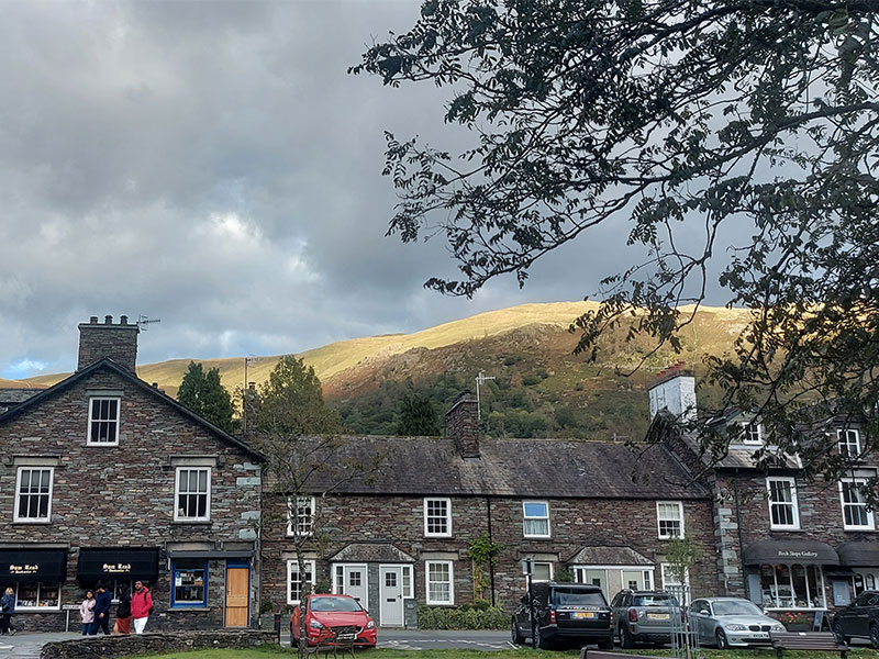 Grasmere bus stop, with as scenic background of village houses and mountains.