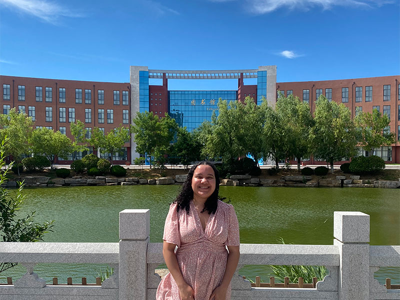 Lyea standing in front of the pond at Lancaster University College at Beijing Jiaotong University.