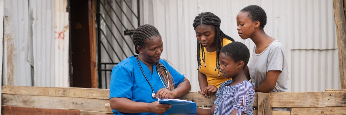 Community Nurse talking to three teenage girls in an informal settlement, Stellenbosch South Africa.