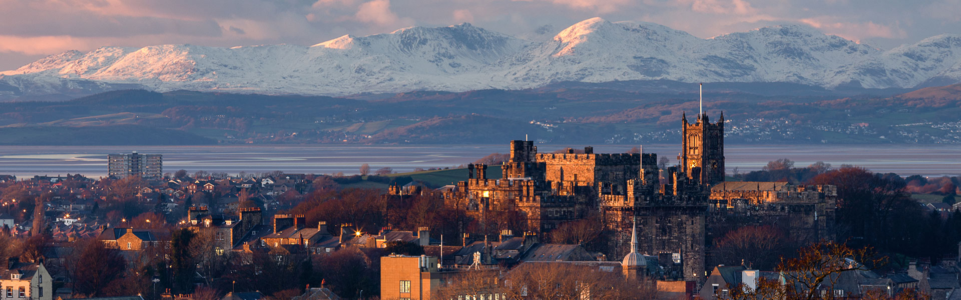 Lancaster skyline with castle in foreground and Morecambe Bay in background.