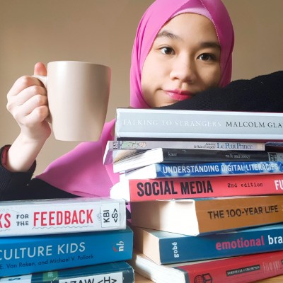 Nurin with pile of books