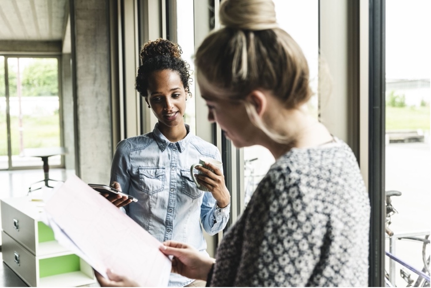 Two women in workplace looking at document