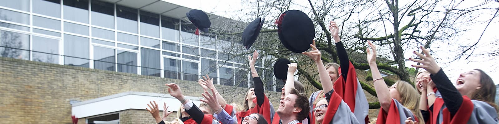 Graduands throwing their mortars into the air.