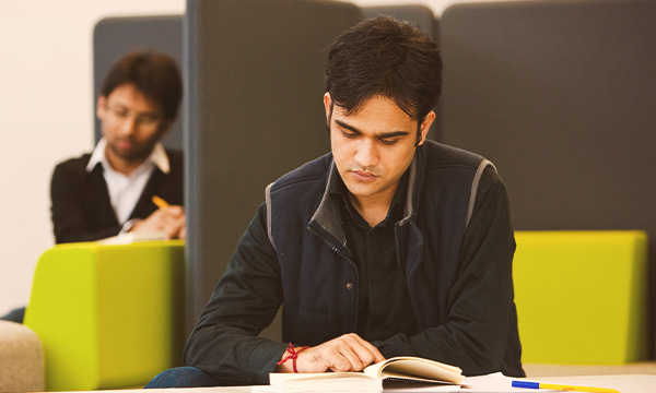 A student reading a book in the library.