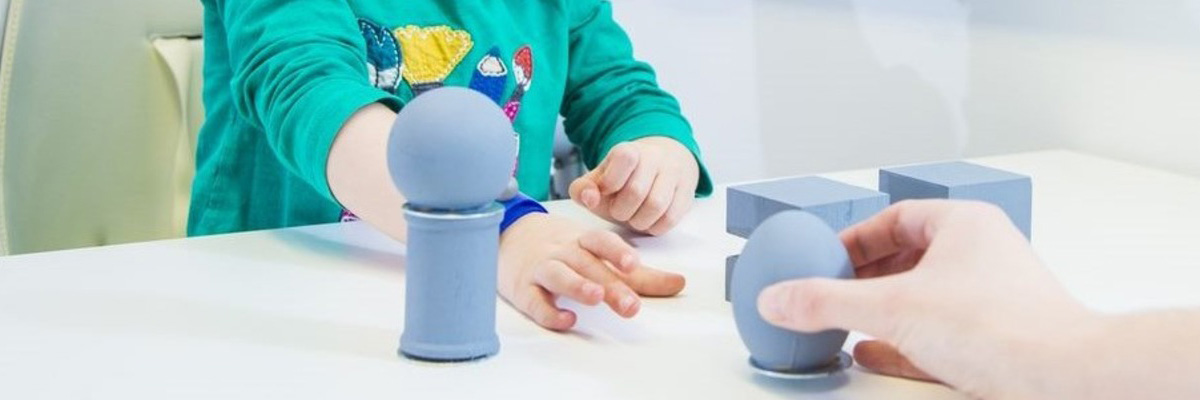 A child and parent playing with some blue coloured blocks