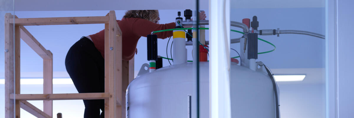 A student adding a sample to the Solid State NMR