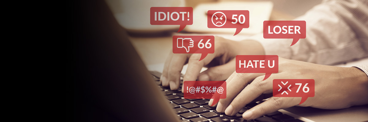 A person on a computer surrounded by hurtful social media messages