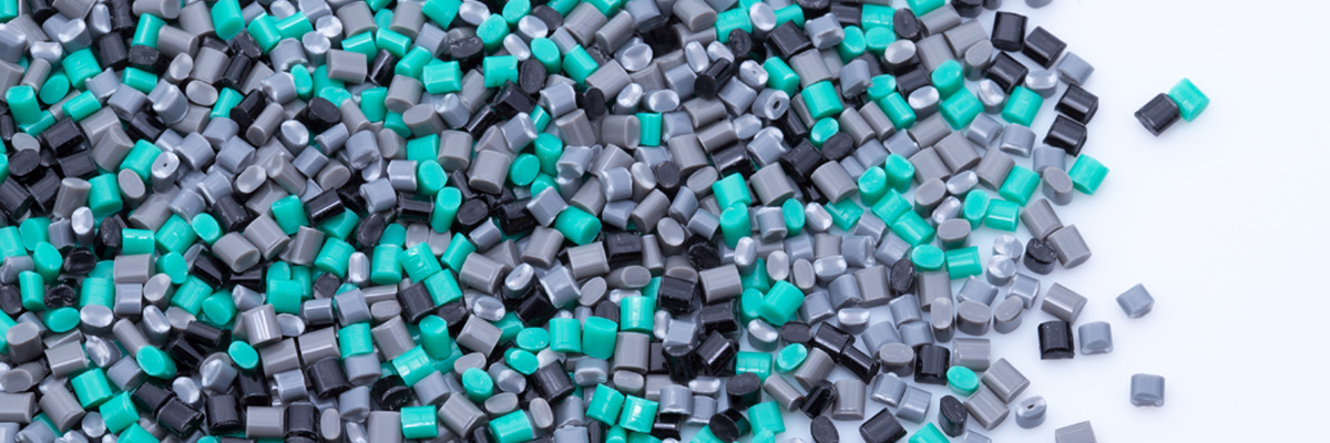 Plastic pellets in grey, green, and black