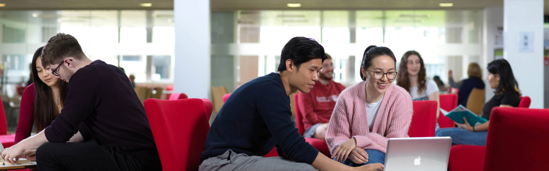 three students sitting at a table in the infolab building 