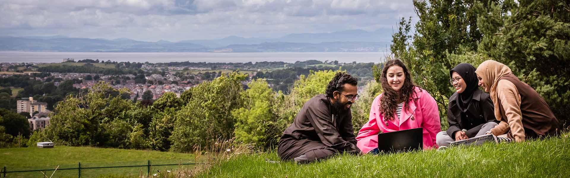 Students in a field overlooking Lancaster and the Lake District