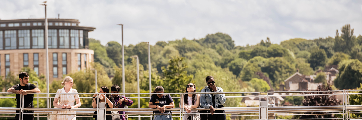 Students standing on a bridge in Lancaster city centre. 