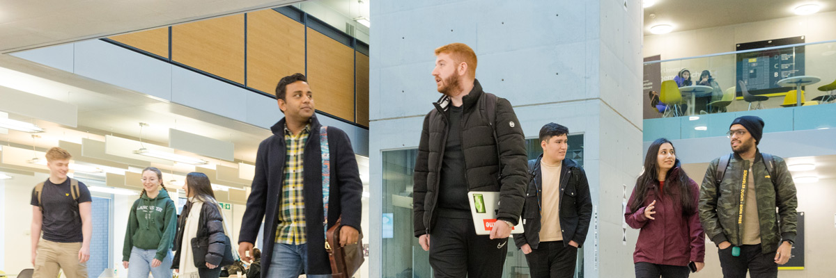 Student walking in Lancaster University Charles carter building