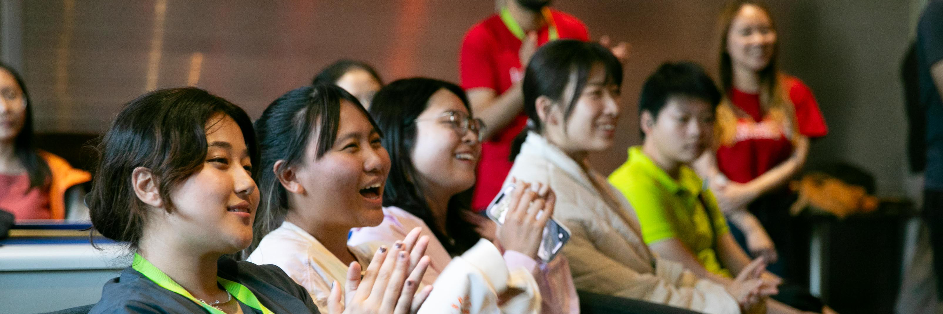 Global Summer School students in the audience clapping during 2023 social event