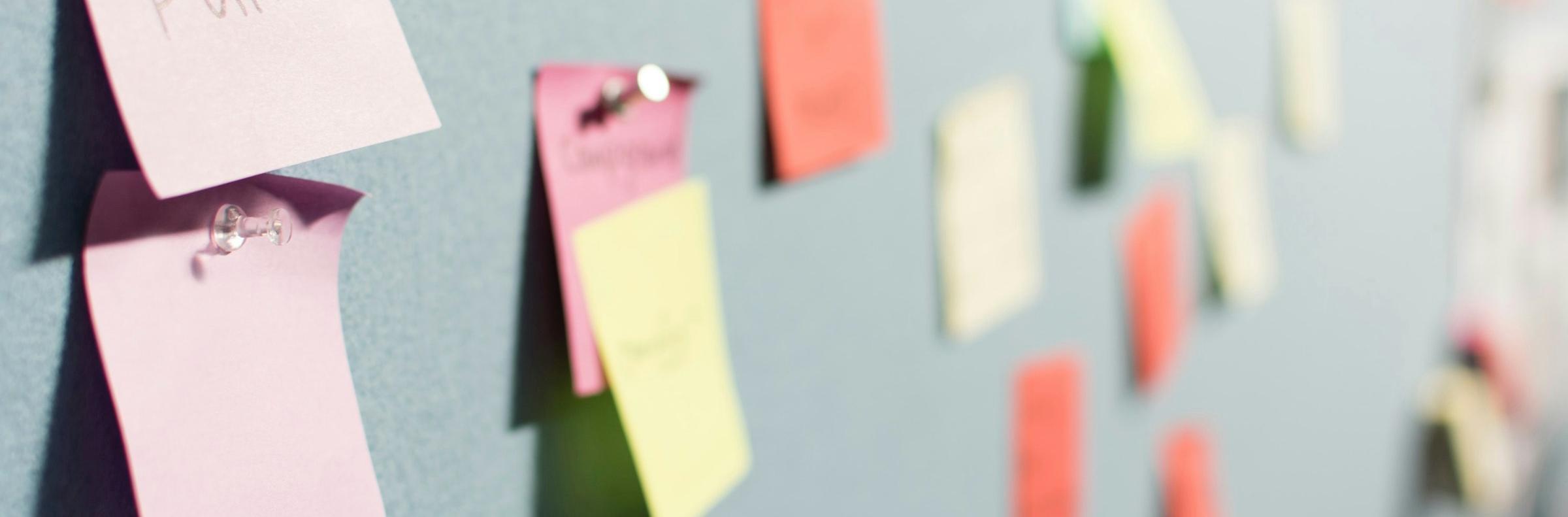 People planning a project with post-its on blackboard