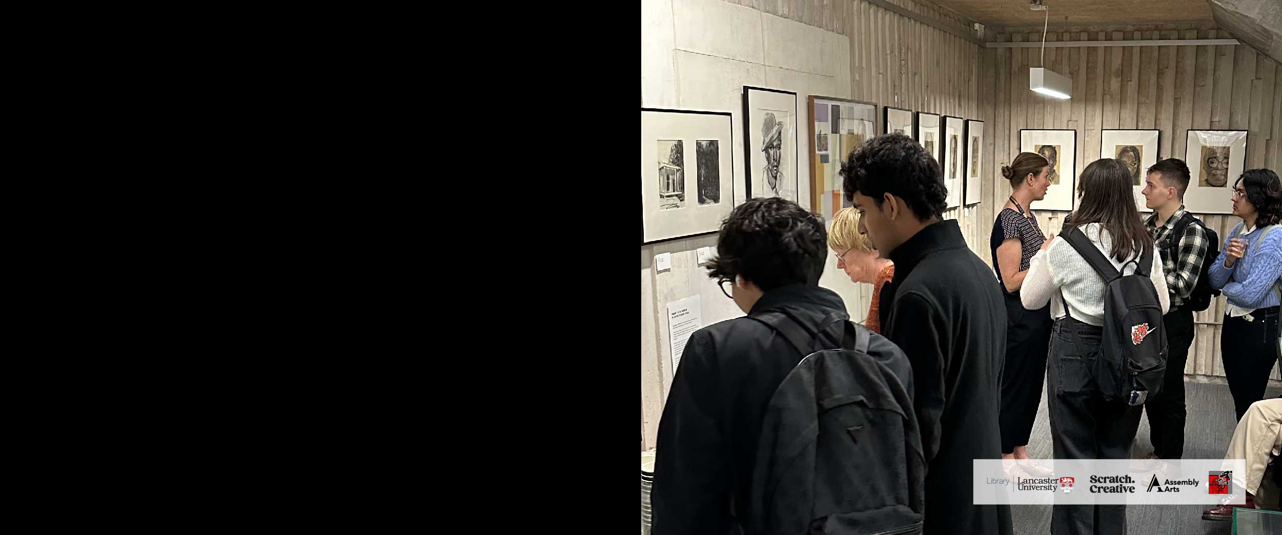 People viewing an exhibition of paintings in the library.