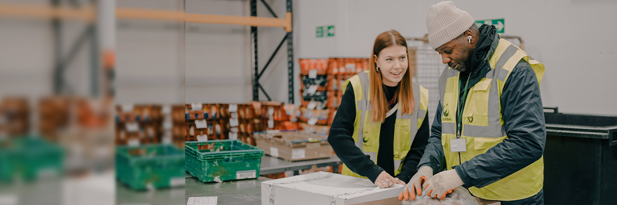 Two people packing food in a warehouse