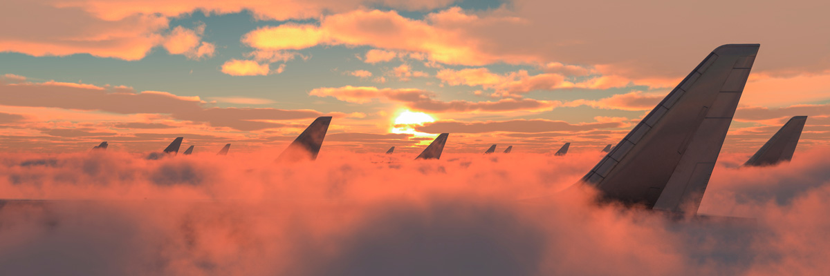 Clouds with aeroplanes showing through, under orange light