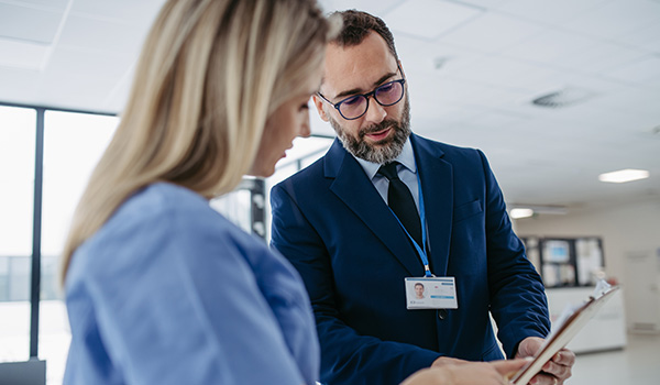 Two professionals in the healthcare industry speaking in a hospital setting