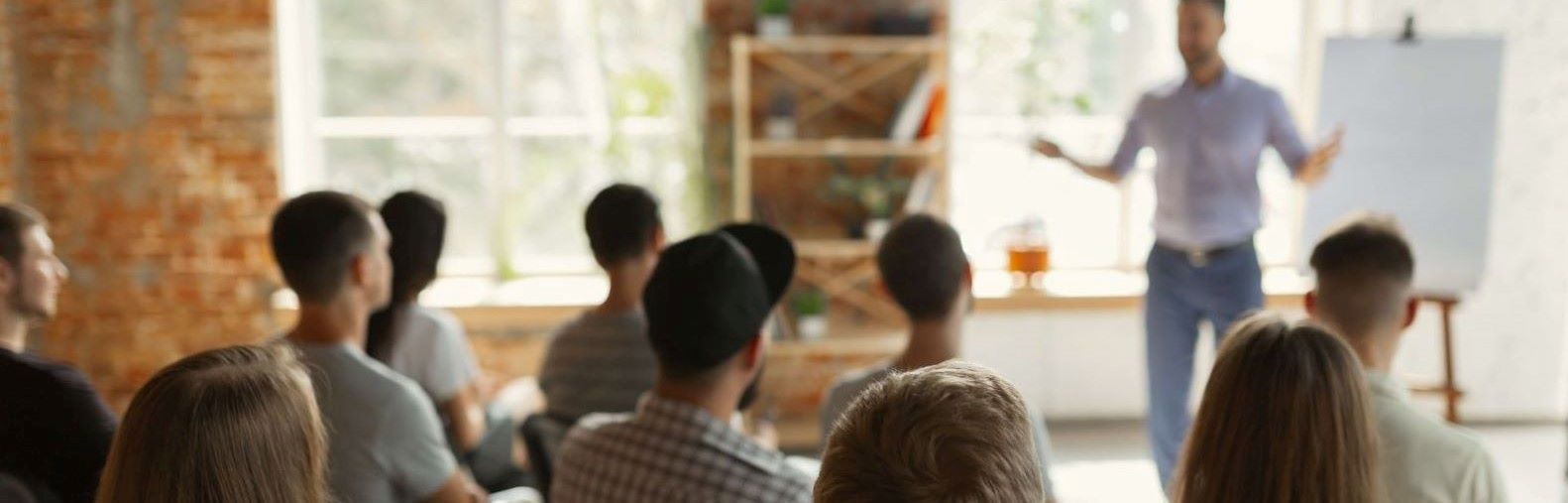 People sat in a training workshop listening to the presenter.