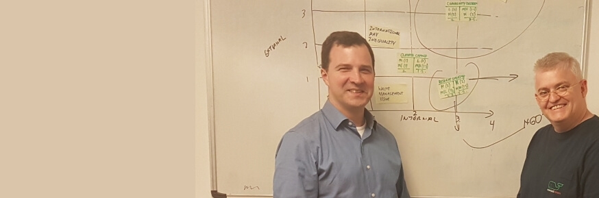 Dr. Todd Cort and Prof. Rodney Irwin standing in front of a whiteboard with a graph drawn on it.