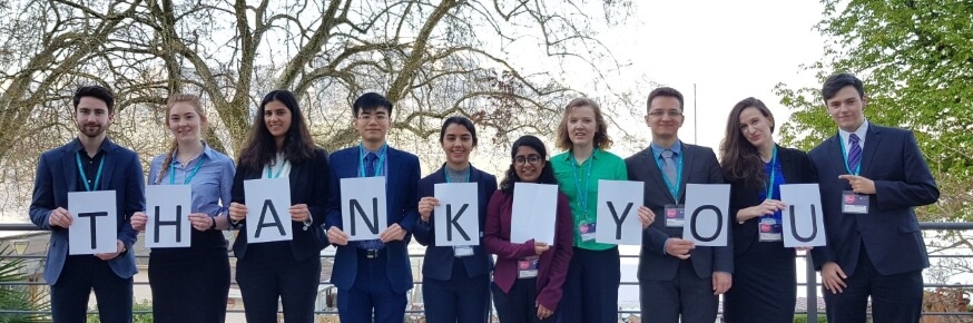 Students standing in a line holding up paper with the letters spelling out THANKYOU