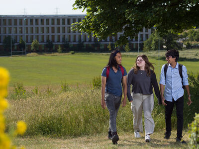 Three researchers walking through the grounds of the HIC building 