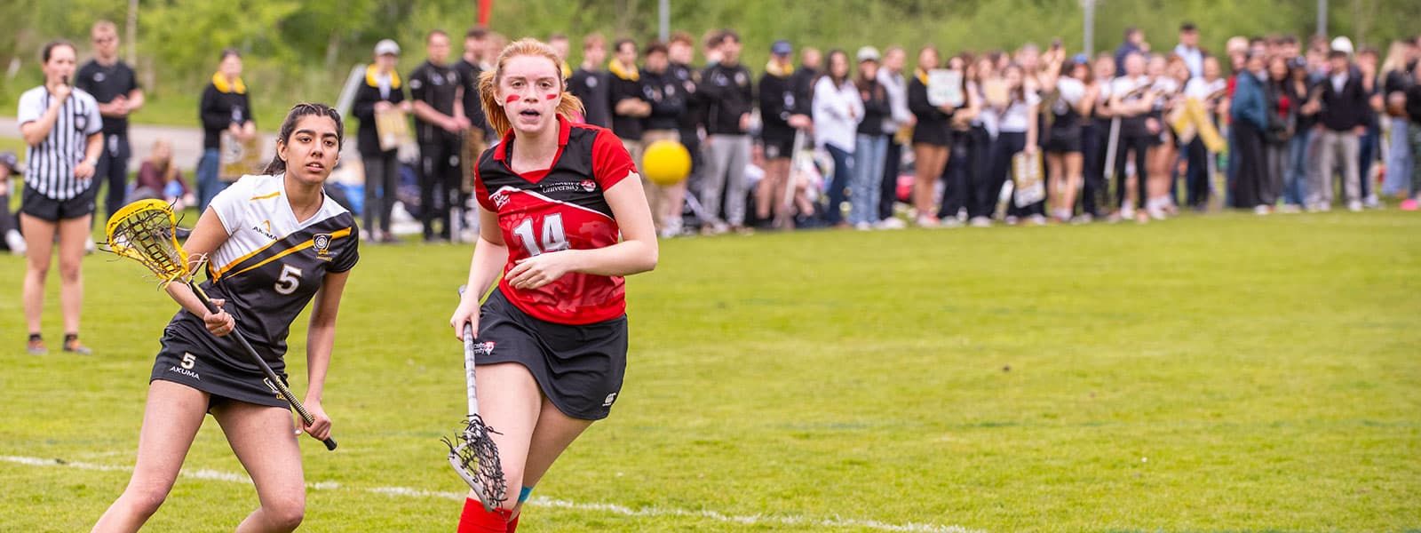 Two girls play lacrosse at Lancaster University.