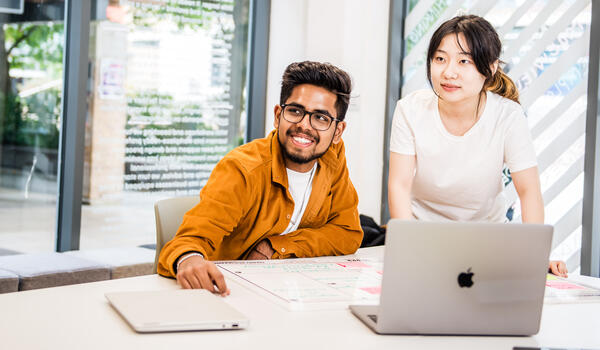 Students at a table working with a laptop