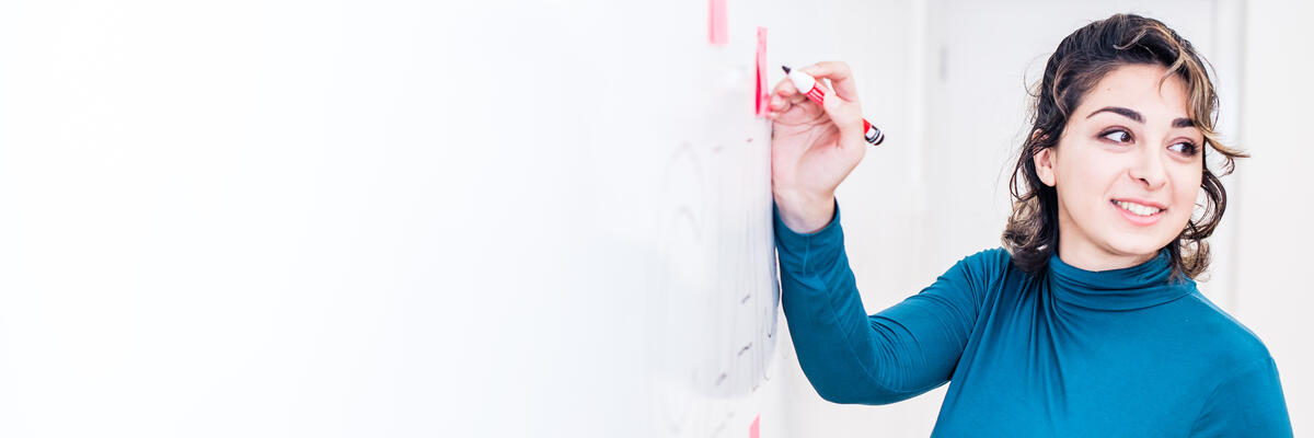 A student writes on a whiteboard