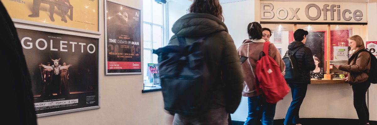 A line of people queue up at the Dukes Theatre box office