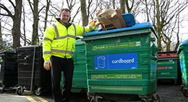 Man stood by a recycling bin